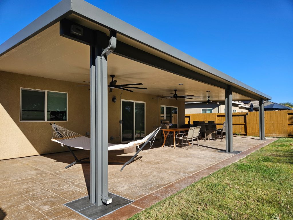 Backyard Patio cover with blue sky and a hammock underneath.